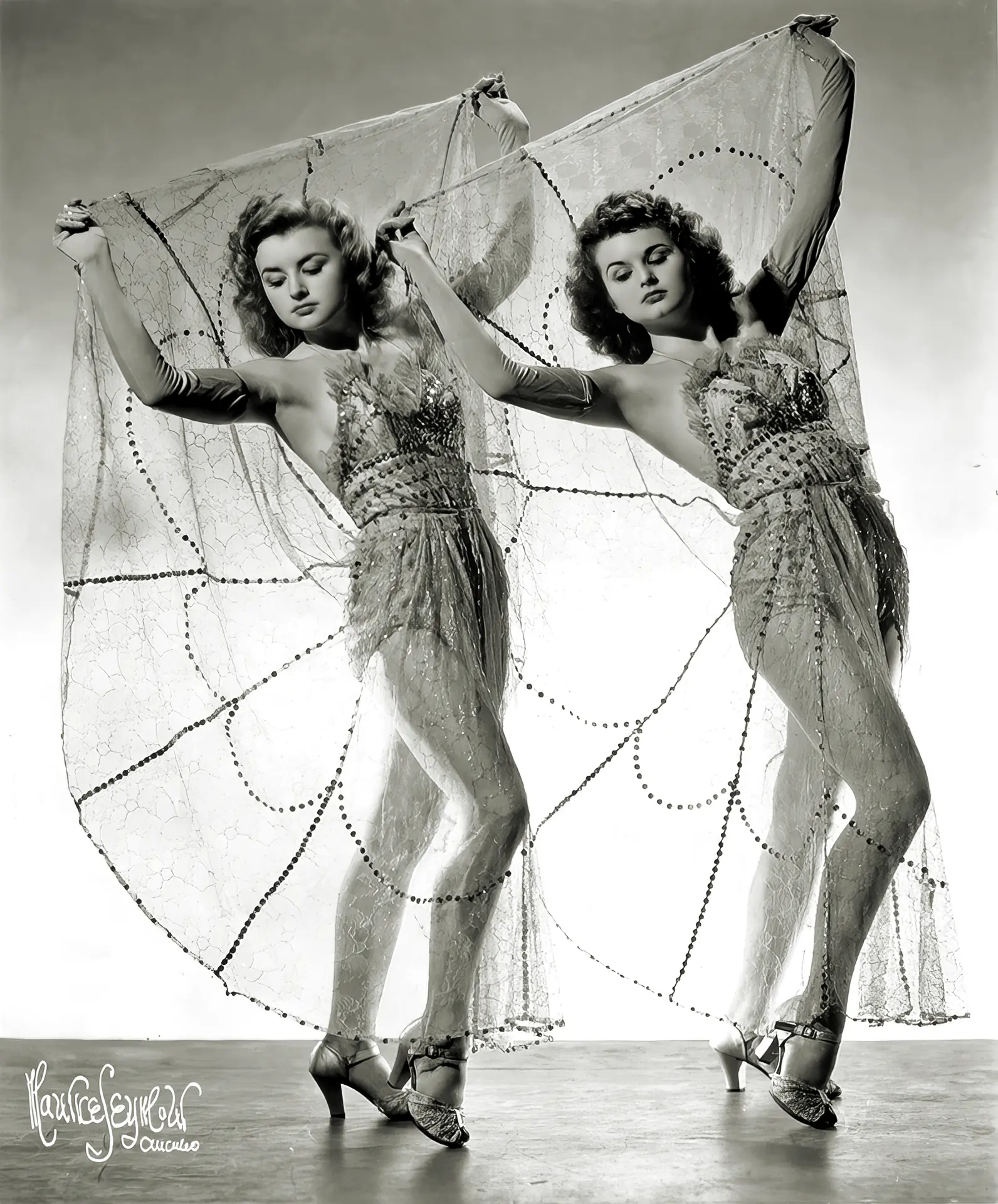 Two curly vintage ladies in burlesque dresses pose identically