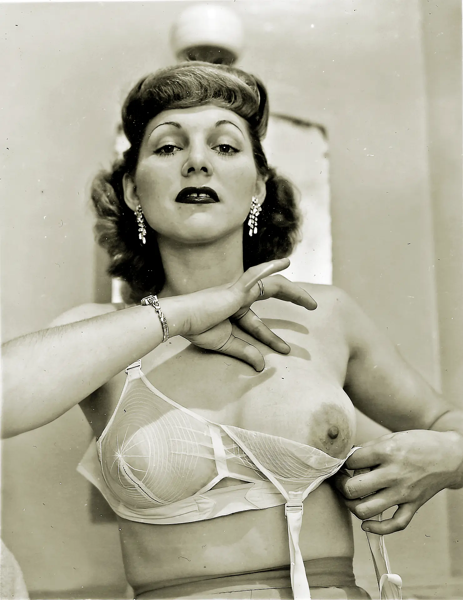 Vintage bra porn photos with mature woman getting her big tits with large nipple areolas out of a white bra in the 1940s