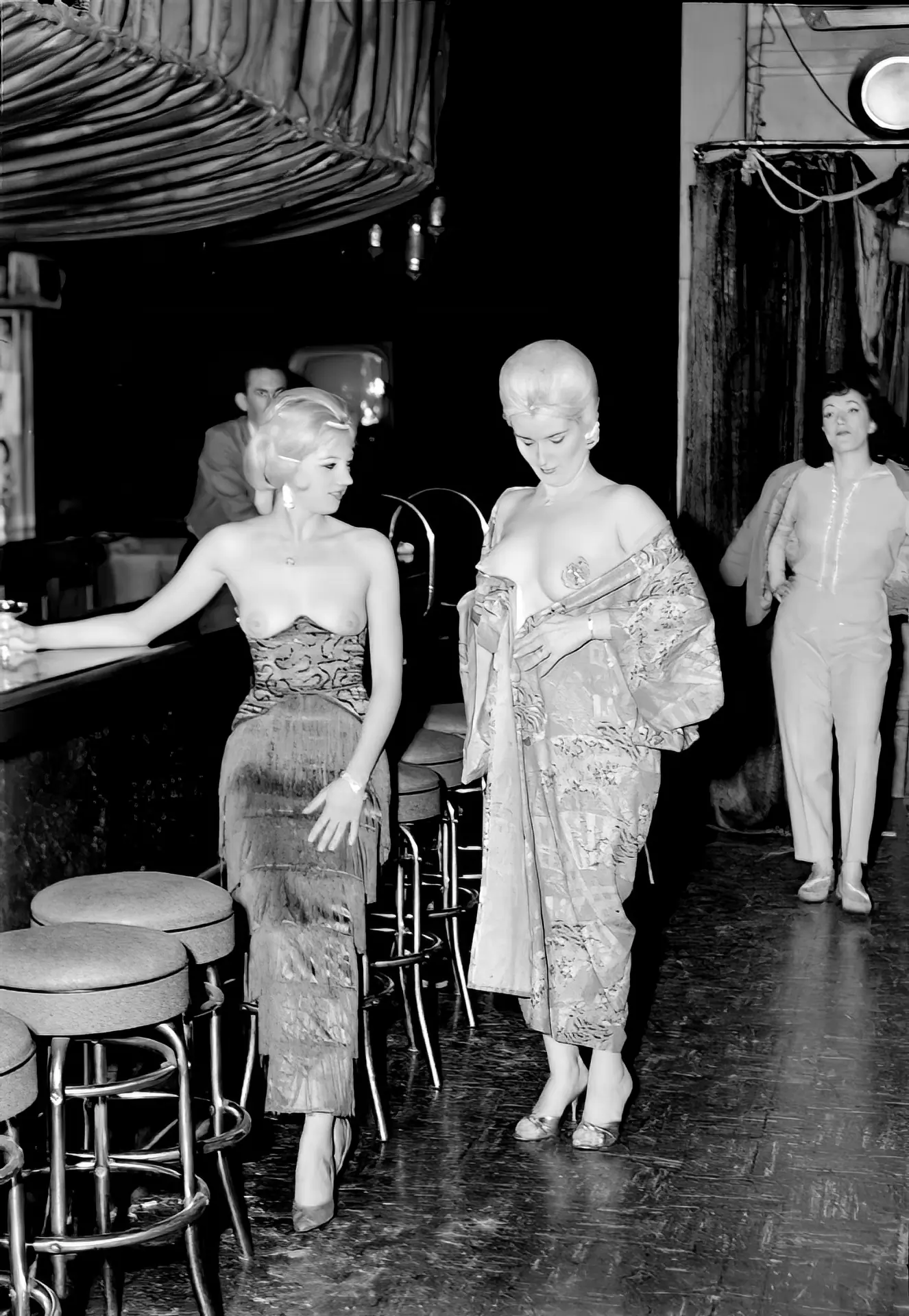 Topless burlesque ladies wear long dresses in a theatre