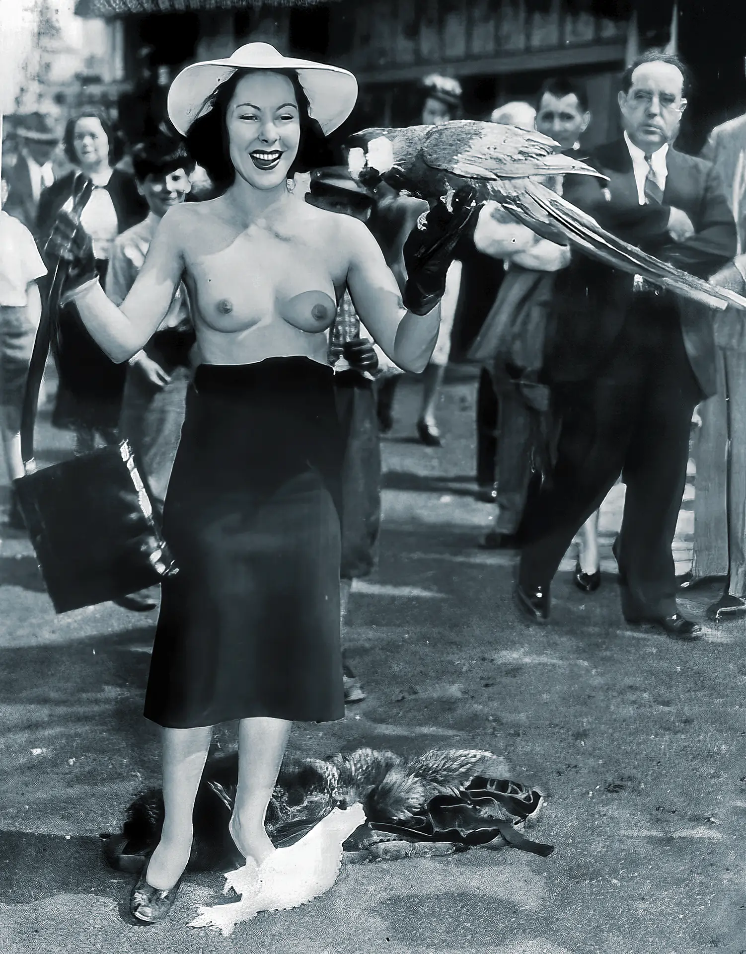 Vintage topless porn photos with bare-breasted woman with a hat and skirt standing in a crowded street outdoors with a parrot in her hand