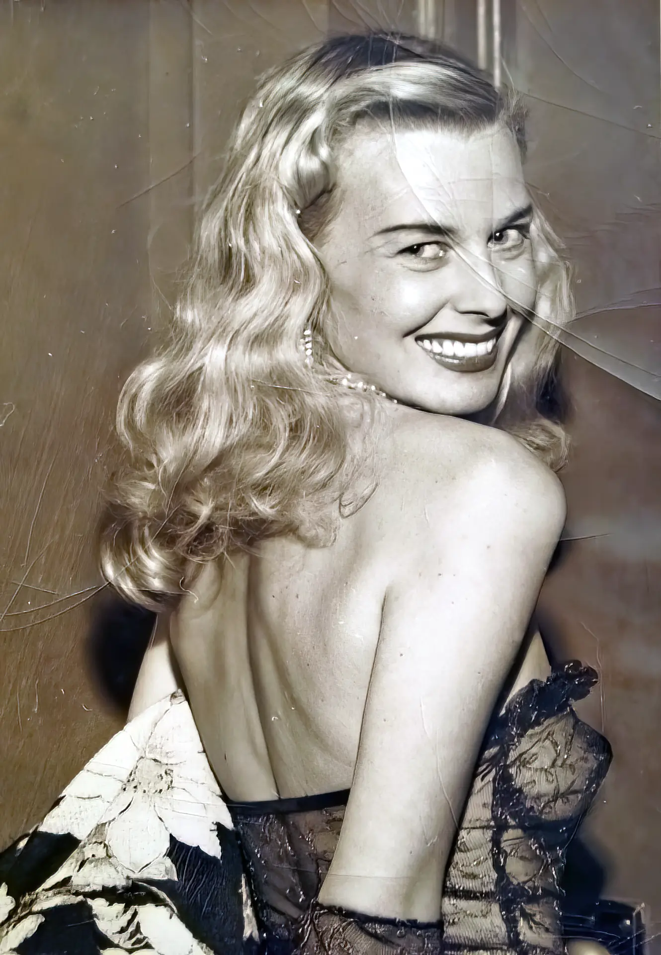 Vintage blonde in a transparent top smiles at the camera