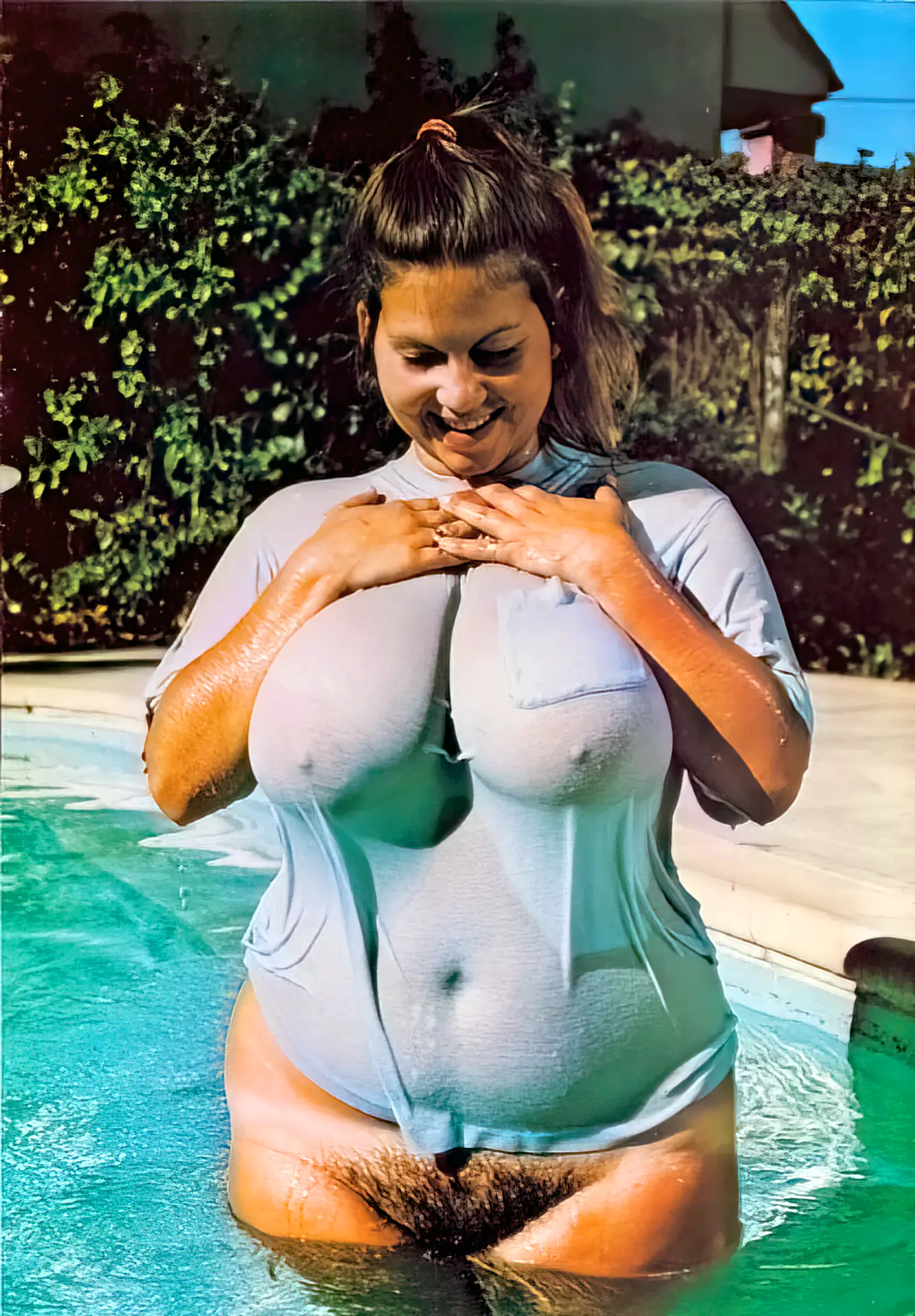 Karen Brown wearing a wet shirt soaks her bush into the pool